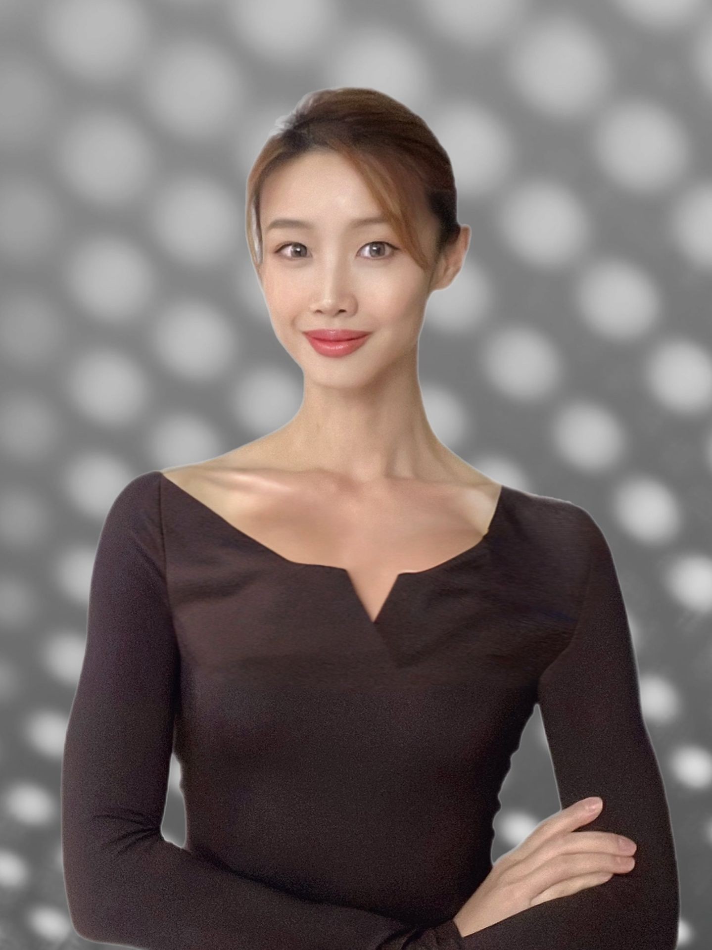 Person in a black top with a blurred polka dot background.